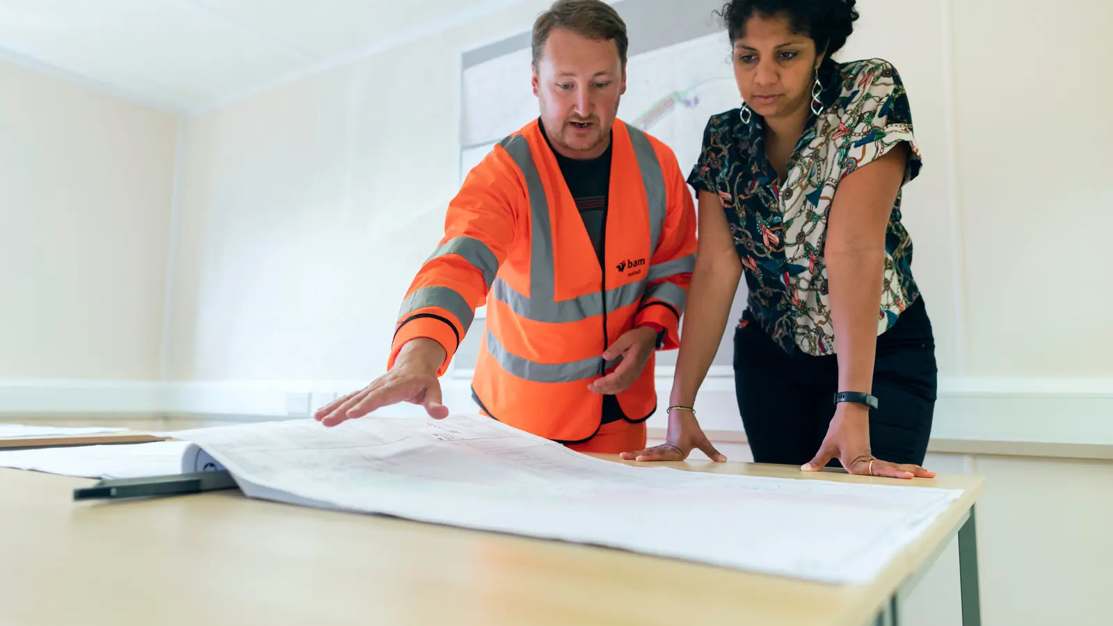 Engineers reviewing detailed project plans together